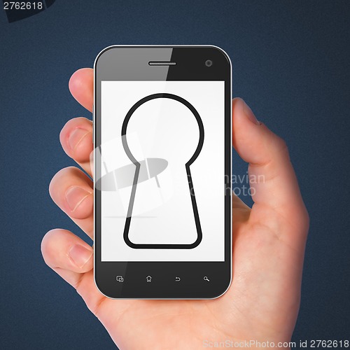 Image of Hand holding smartphone with keyhole on display.