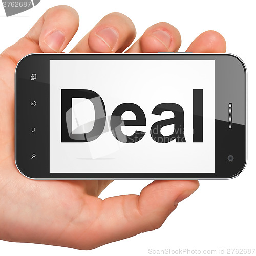 Image of Hand holding smartphone with word Deal on display. Generic mobil