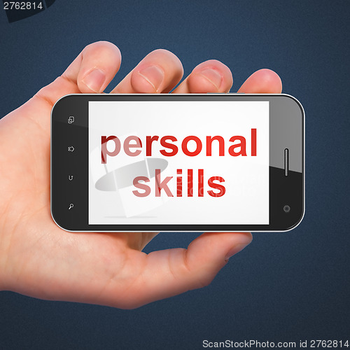 Image of Hand holding smartphone with word personal skills