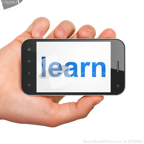 Image of Hand holding smartphone with word learn on display