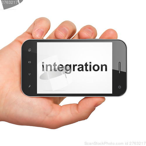 Image of Hand holding smartphone with word integration on display. Generi