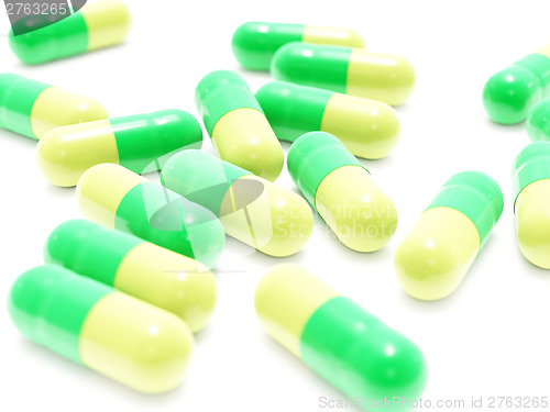 Image of Many green-yellow pills on white