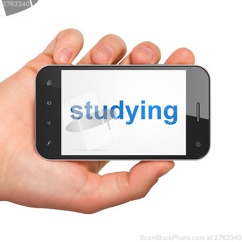 Image of Hand holding smartphone with studying on display