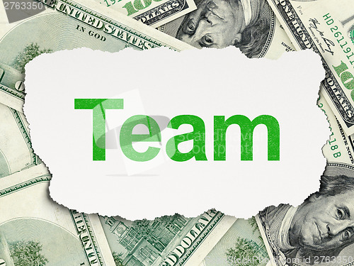 Image of Torn paper with words Team on money background