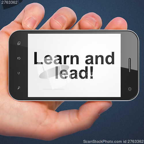 Image of Hand holding smartphone with word Learn and lead