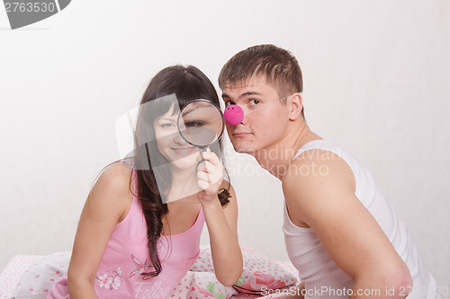 Image of Girl with magnifying glass, guy clown nose