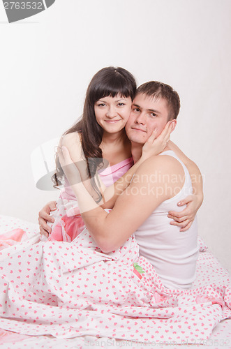 Image of Young beautiful girl embraces the guy in bed