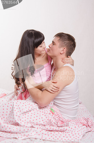 Image of Young couple kissing in bed