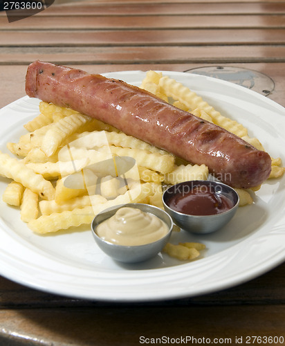 Image of authentic kielbasa Polish sausage with french fries as photogpra