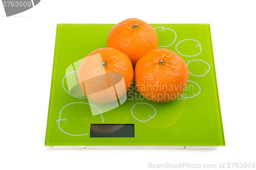 Image of Three sweet mandarin on scales