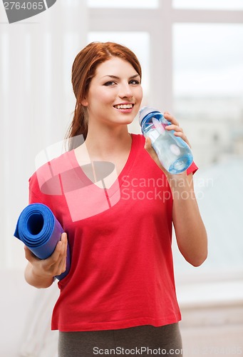 Image of smiling girl with bottle of water after exercising