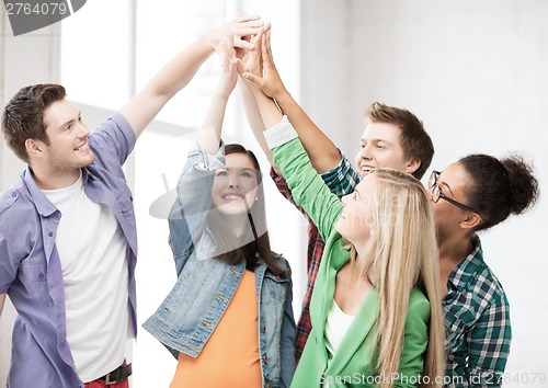Image of happy students giving high five at school