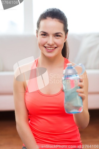 Image of smiling girl with bottle of water after exercising