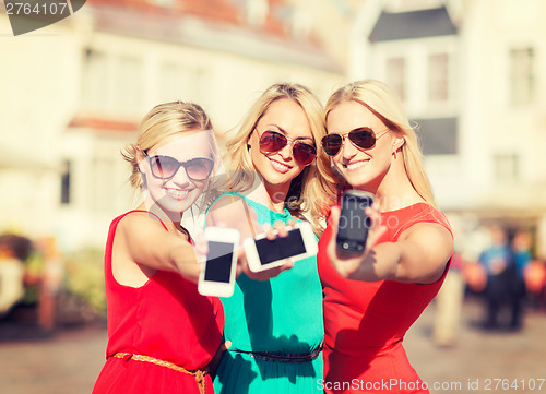 Image of beautiful girls with smartphones in the city