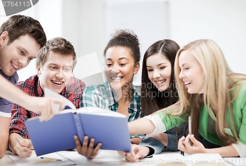 Image of students reading book at school