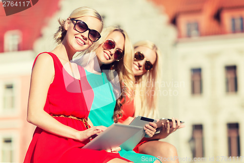 Image of beautiful girls toursits looking into tablet pc