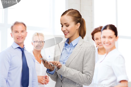 Image of young smiling businesswoman with smartphone