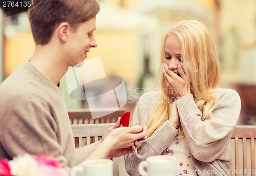 Image of romantic man proposing to beautiful woman