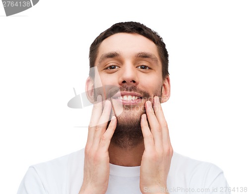 Image of beautiful smiling man touching his face