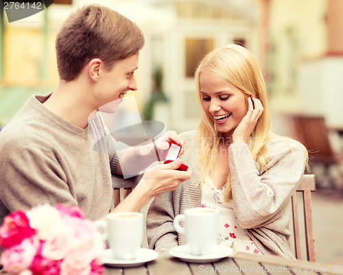 Image of romantic man proposing to beautiful woman