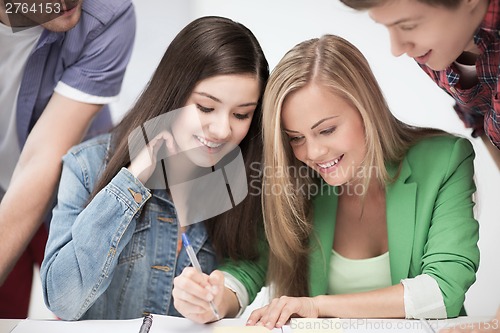 Image of students pointing at notebook at school