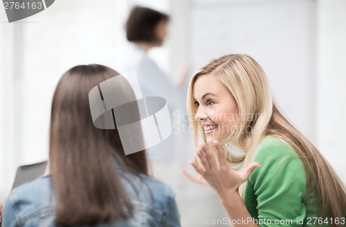 Image of student girl gossiping in lecture at school