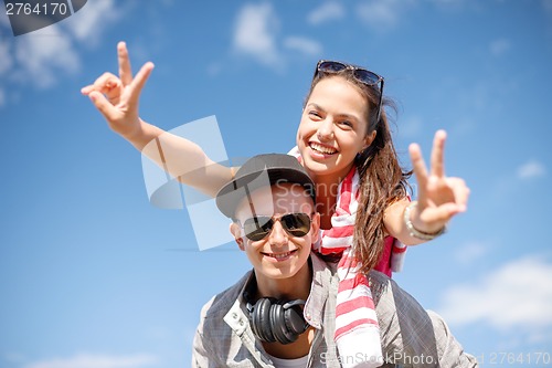 Image of smiling teenagers in sunglasses having fun outside