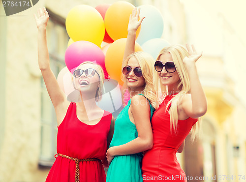 Image of beautiful girls with colorful balloons in the city