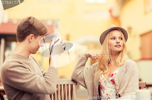 Image of couple taking photo picture in cafe