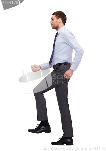 Image of serious businessman stepping on imaginary step