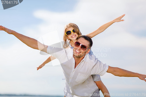 Image of happy father and child in sunglasses over blue sky