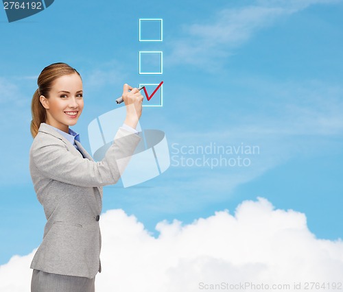 Image of businesswoman writing something in air with marker