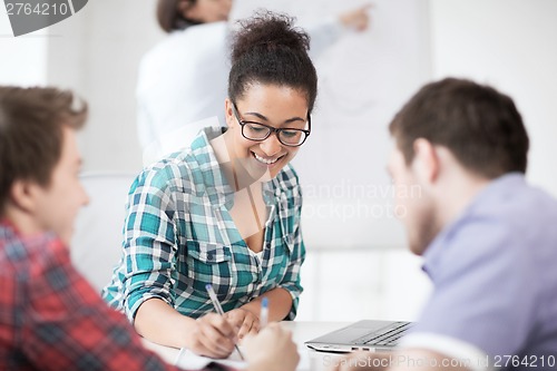 Image of african student writing something in notebook