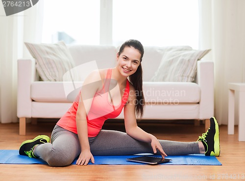 Image of smiling teenage girl streching on floor at home