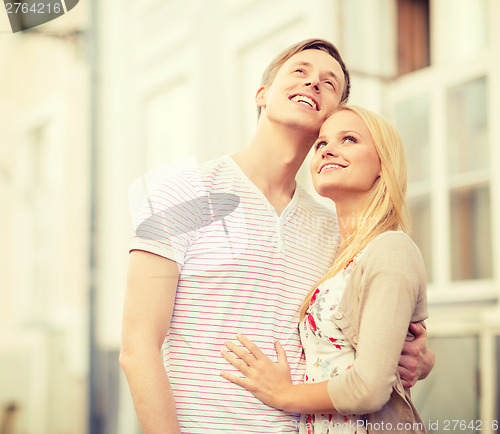 Image of romantic couple in the city looking up