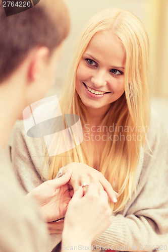 Image of romantic man proposing to beautiful woman