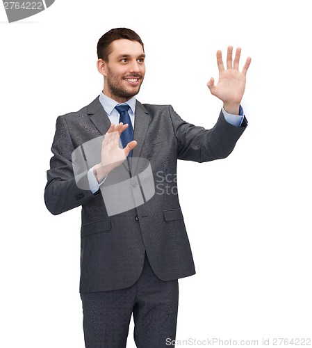 Image of businessman working with imaginary virtual screen