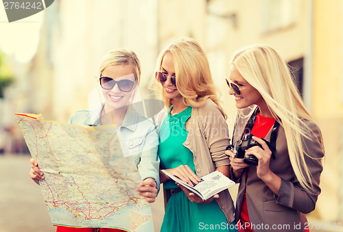 Image of beautiful women with tourist map in the city