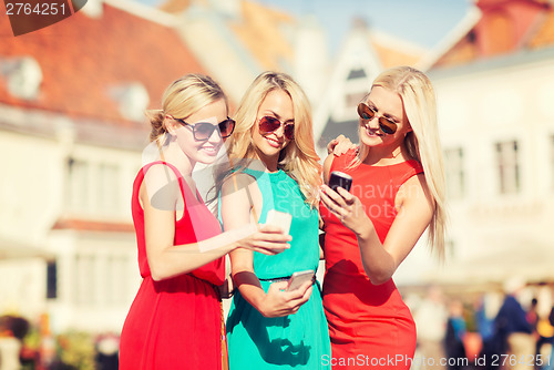 Image of beautiful girls with smartphones in the city