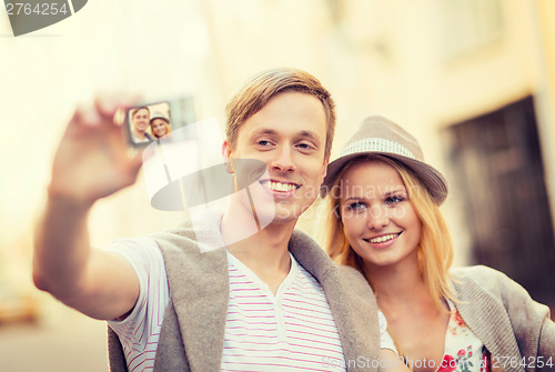Image of travelling couple taking photo picture with camera