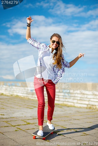 Image of smiling teenage girl riding skate outside