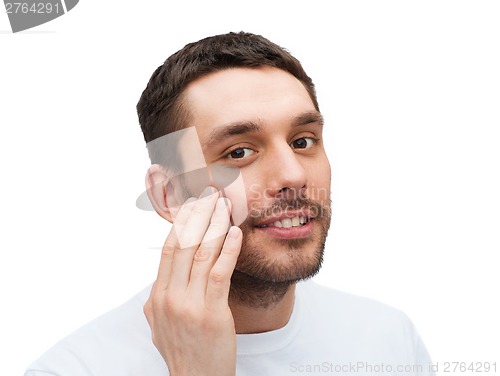 Image of beautiful smiling man touching his face