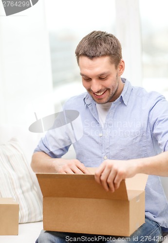 Image of man with cardboard boxes at home