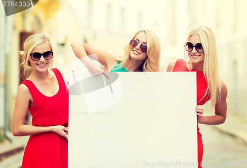 Image of three happy blonde women with blank white board