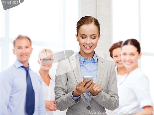 Image of young smiling businesswoman with smartphone