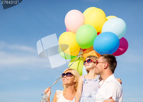 Image of happy family with colorful balloons outdoors