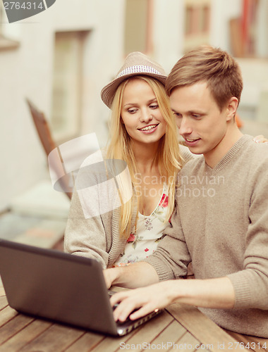 Image of couple with laptop in cafe