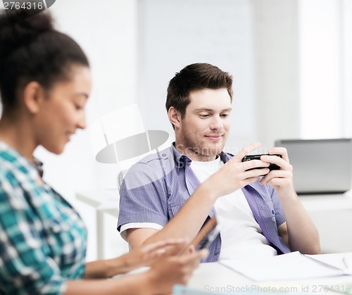 Image of students looking at devices at school