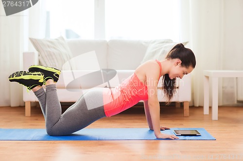 Image of smiling teenage girl doing push-ups at home