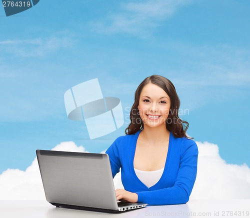 Image of smiling woman in blue clothes with laptop computer